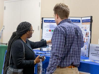 A prospective student (right) visits with Alex Hoffman (BS, 2020) from Christian Counseling Associates of Western Pennsylvania.